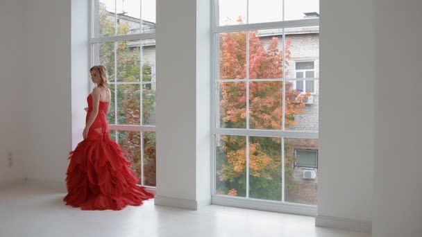 Reizende Frau im roten Kleid posiert im Studio. - Filmmaterial, Video