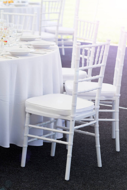 fehér szék és díszes tábla beállítása egy esküvői vacsora - Fotó, kép