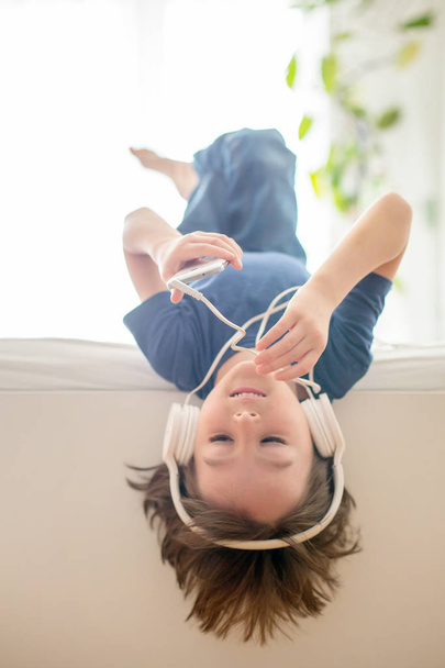 Cute boy with phone and head phones, listening music - Foto, Imagem