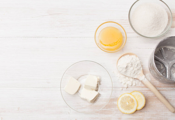Pieces of butter, lemon, honey, flour and sugar on the table - Foto, Bild