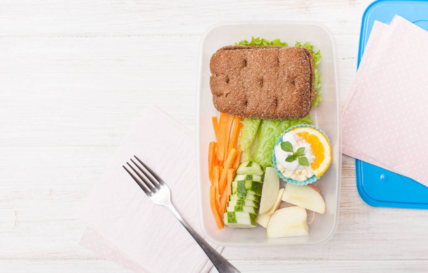 Cut vegetables, sandwich in an open food container - Fotó, kép