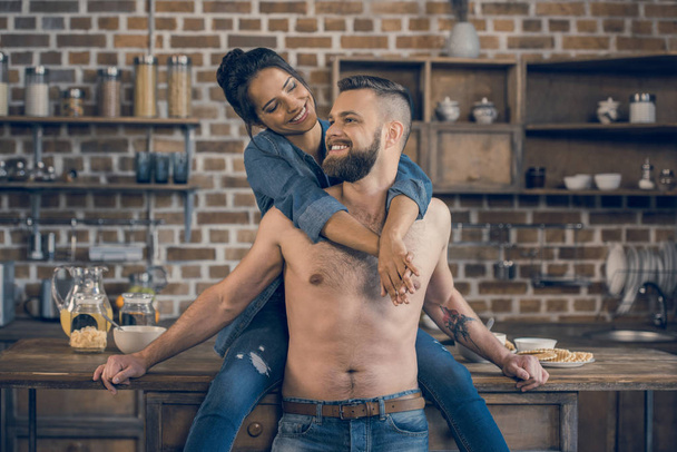 Couple hugging in kitchen  - Foto, afbeelding