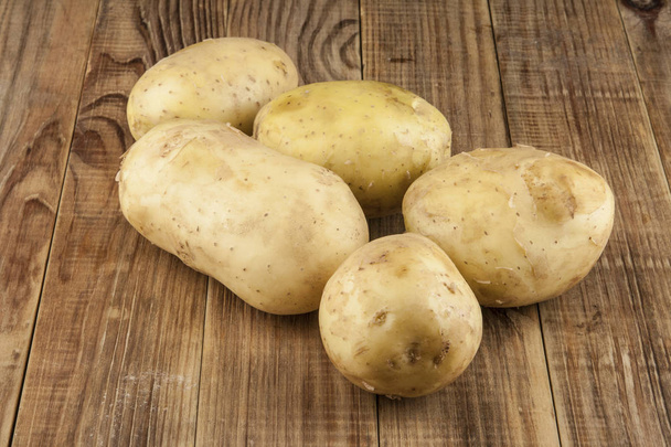 Raw, young potatoes on a wooden table - Photo, Image