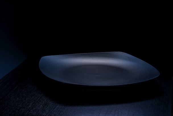 Vista del piatto vuoto nero su sfondo grigio scuro
 - Foto, immagini