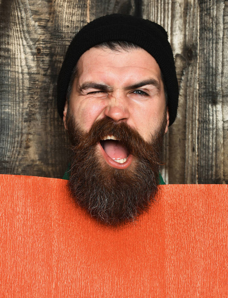 Bearded brutal caucasian hipster with red paper sheet - Фото, зображення