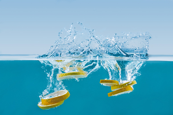 lemon slices falling into water with splashes - Photo, Image