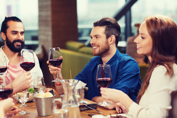 friends dining and drinking wine at restaurant - Zdjęcie, obraz