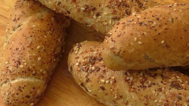Versgebakken heerlijke knapperige broodjes op een rustieke houten aanrecht  - Video