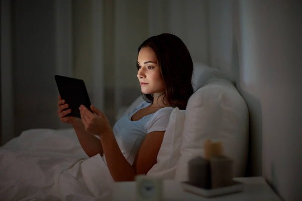 young woman with tablet pc in bed at home bedroom - Valokuva, kuva