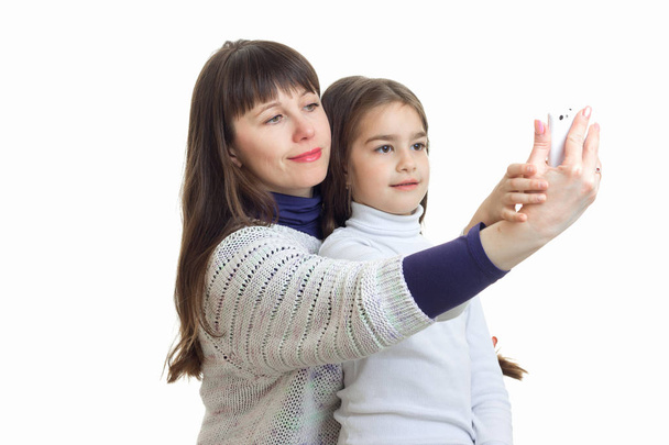 mom with her little daughter make photo on the phone and smiling - Foto, Imagen