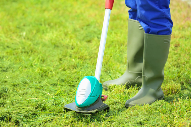 worker mowing lawn with grass trimmer  - Fotografie, Obrázek