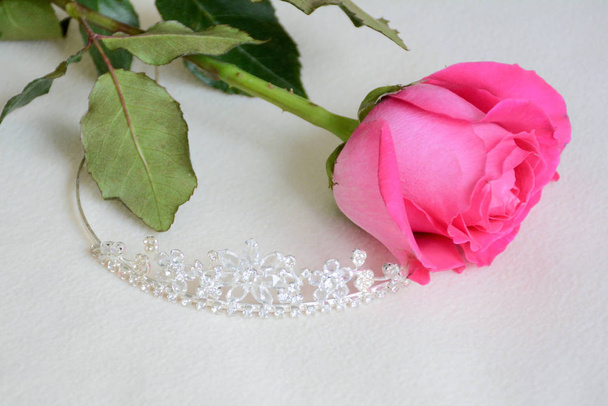Bridal tiara and pink rose on light background - Valokuva, kuva