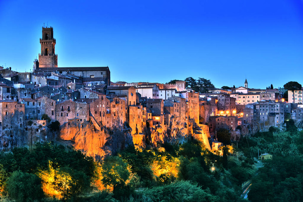 Stad van Pitigliano in Toscane, Italië na zonsondergang - Foto, afbeelding