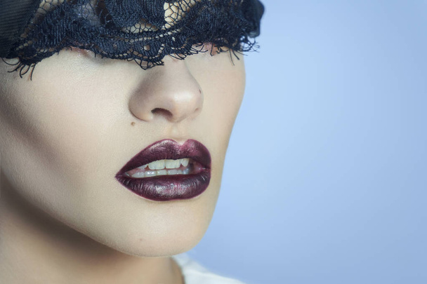 charming young lady with black lace on eyes and beautiful lips - Foto, afbeelding