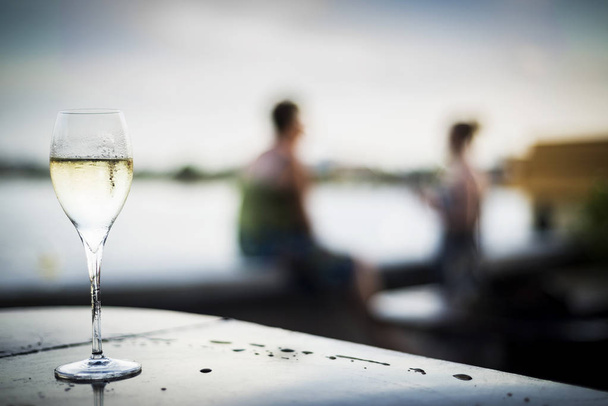 келих шампанського в сучасному відкритому барі на заході сонця
 - Фото, зображення