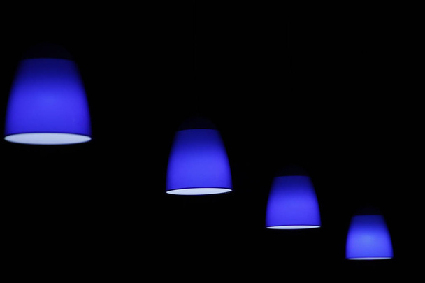 Luminária azul contra fundo escuro
 - Foto, Imagem