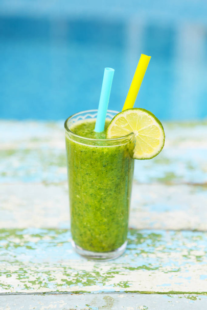 Tuore sekoitettu vihreä hedelmä smoothie lasi olki
 - Valokuva, kuva