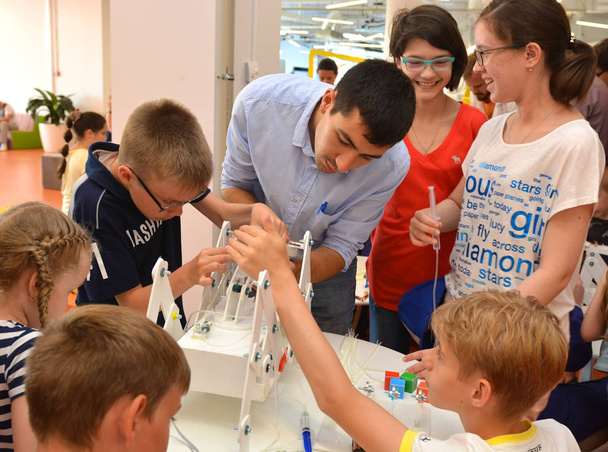 Team work on robotics under the guidance of a teacher at an open lesson in Russia - Photo, Image