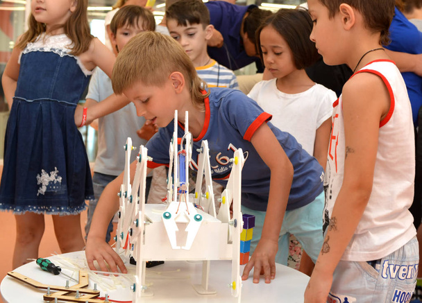 The team of junior schoolchildren discusses the stage of designing a robot - Фото, зображення