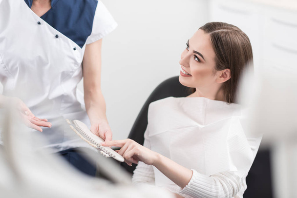 Outgoing female choosing artificial tooth - Fotografie, Obrázek