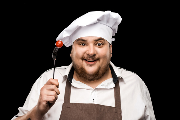 Chef che tiene pomodoro sulla forchetta
  - Foto, immagini
