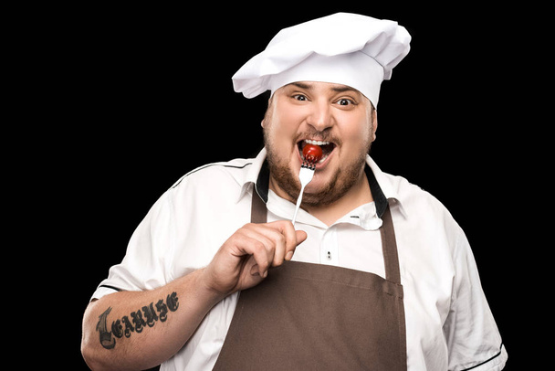 Chef che tiene pomodoro sulla forchetta
  - Foto, immagini