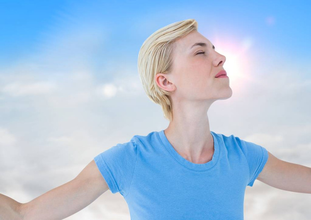 woman with arms outstretched against sunny sky - Foto, immagini