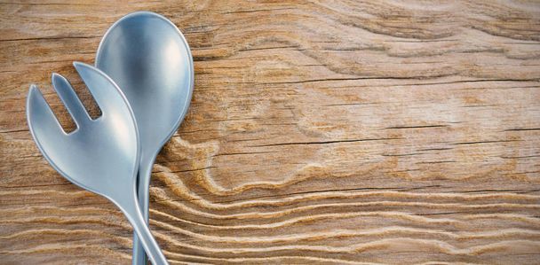 Spoon and fork on wooden table - 写真・画像