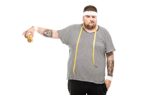 man with measuring tape holding burger - Photo, Image