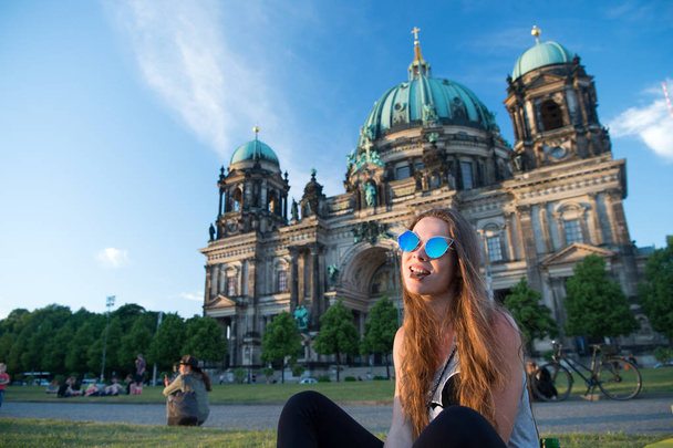Pretty gil sitting in front of Berlin Cathedral eat chocolate - Фото, изображение