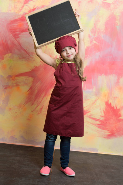 smiling kid, happy girl cook in red chef hat, apron - Fotoğraf, Görsel