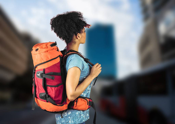 Millennial backpacker searching on blurry street - Foto, Imagen