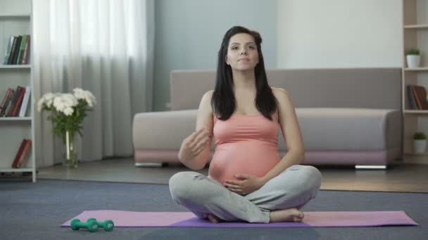 Woman restoring inner harmony and balance, doing yoga before giving birth - Materiał filmowy, wideo