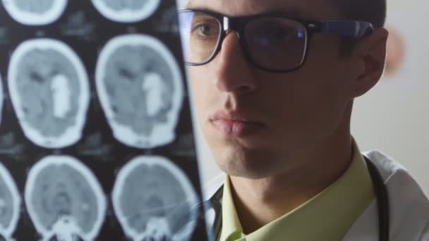 Ein Neurochirurg betrachtet eine Magnetresonanztomographie des Gehirns. Der Arzt diagnostiziert einen Schlaganfall - Filmmaterial, Video
