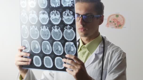 Ένας νευροχειρουργός γιατρός εξετάζει ένα στιγμιότυπο μαγνητική τομογραφία Mri του εγκεφάλου - Πλάνα, βίντεο