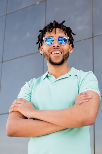giovane uomo americano sorridente felice con occhiali da sole ritratto all'aperto
 - Foto, immagini