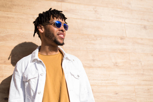 jovem americano homem sorrindo feliz com óculos de sol retrato ao ar livre
 - Foto, Imagem