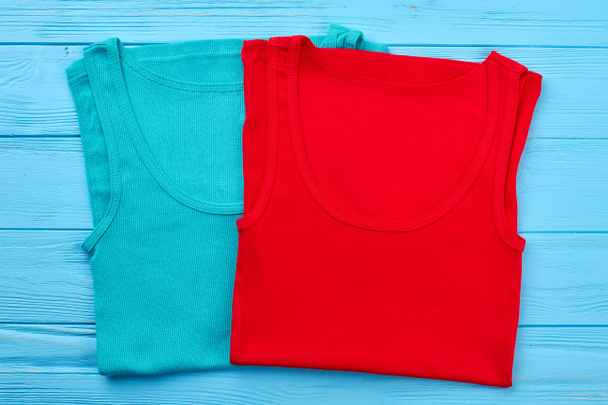 Two colored t-shirts, wooden background. - Foto, Imagem
