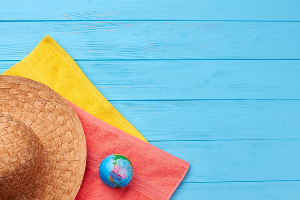 Colored towels, straw hat, globe. - Foto, afbeelding
