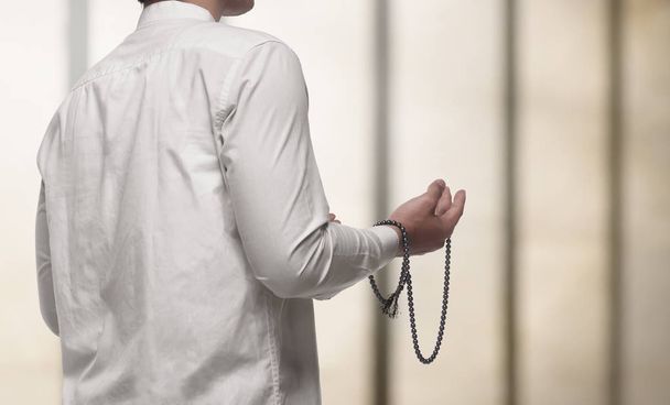 Portrait of muslim man praying with prayer beads - Fotografie, Obrázek