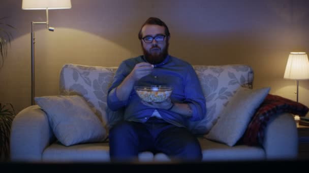 Man Sitting on a Sofa in Living Room - Filmati, video