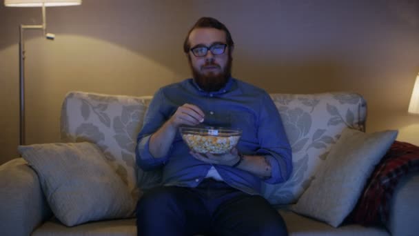 Man Sitting on a Sofa in Living Room - Materiał filmowy, wideo