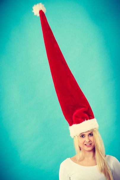 Woman wearing windblown crazy santa hat - Фото, изображение