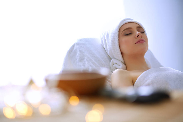 Young woman lying on a massage table,relaxing with eyes closed. Woman. Spa salon - Fotó, kép