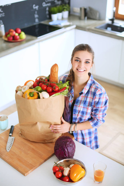 Young woman holding grocery shopping bag with vegetables . - Photo, Image
