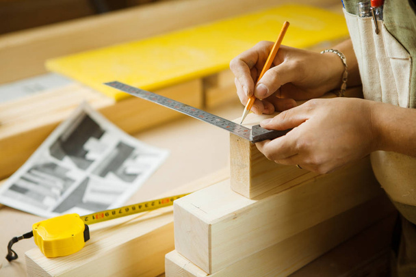 Craftsman measure wooden planks with help of ruler. Woodworker workshop - Fotó, kép