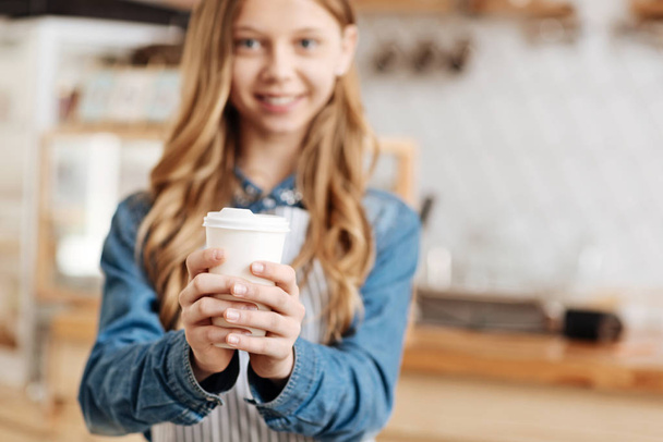 Jolie cafetière tenant une tasse de café avec les deux mains
 - Photo, image