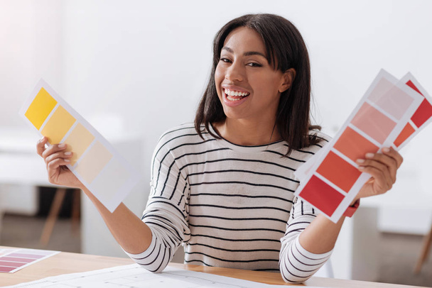 Happy positive woman holding colored pieces of paper - Fotoğraf, Görsel