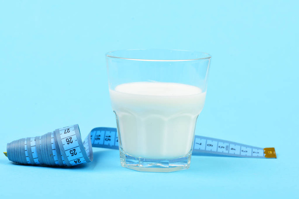 Glass of milk and untwisted roll of tape for measuring - Photo, image