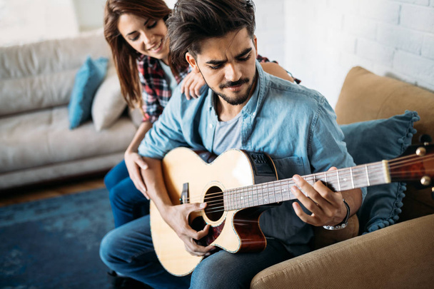 man playing guitar for his girlfriend - Zdjęcie, obraz
